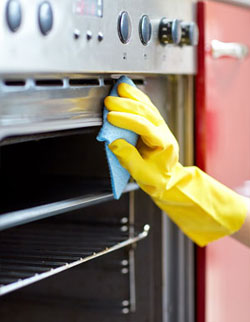 yellow glove cleaning oven up close